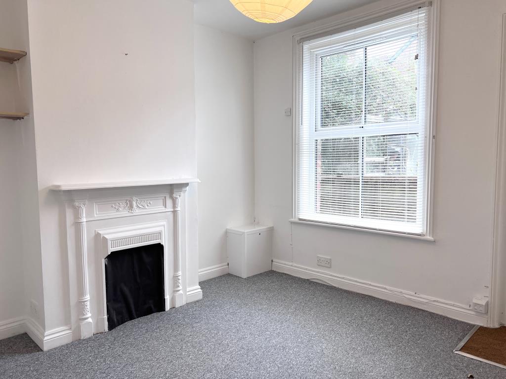 Lot: 65 - TWO-BEDROOM COTTAGE FOR INVESTMENT OR OCCUPATION - White painted walls with grey carpet and fireplace